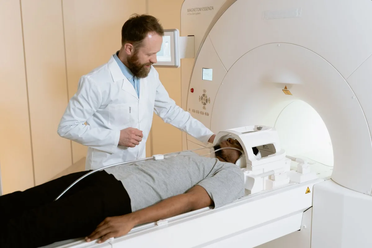 A clinician preparing a patient for an MRI scan.