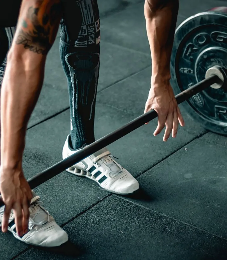 An athlete preparing to lift a barbell during a strength training session.